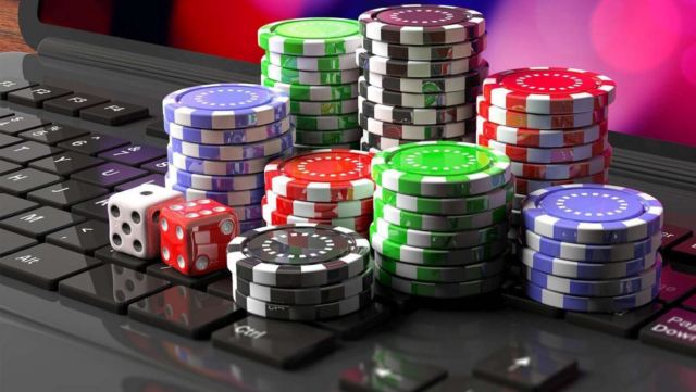 Casino tokens and dice on a laptop representing online casinos